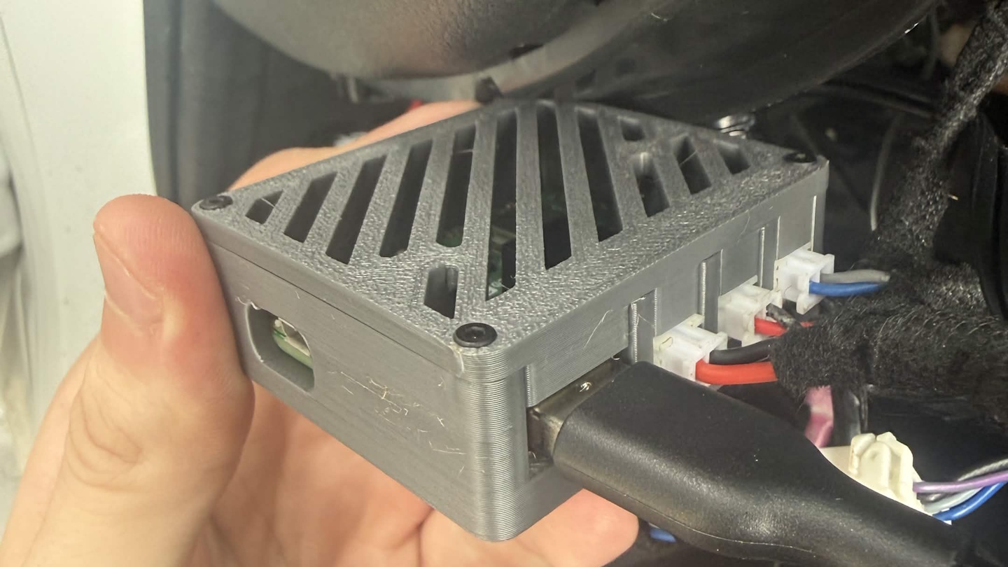 A small box with 4 cables coming out of it, and a port for a USB cable.