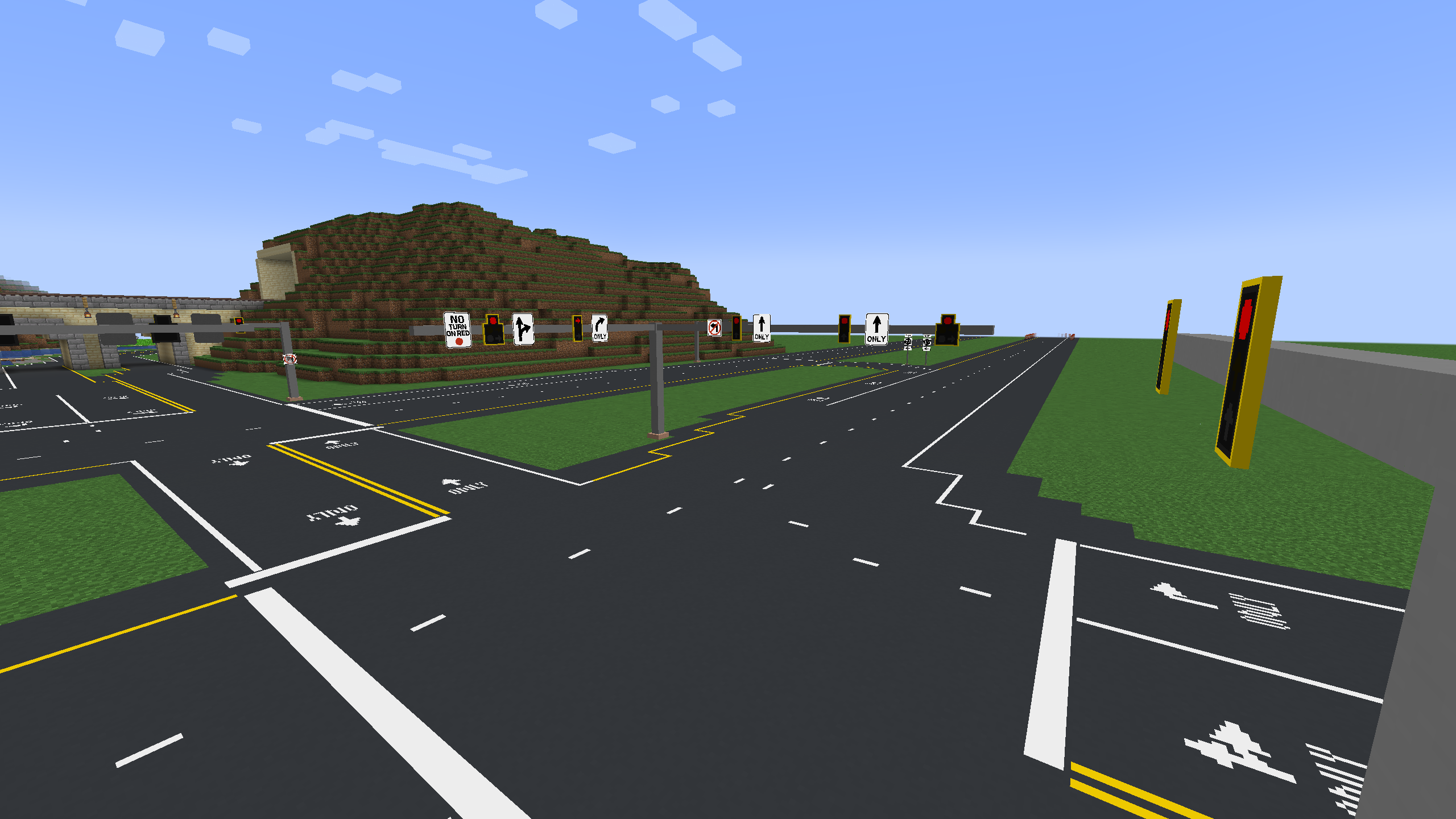 An complex highway intersection, similar to a Michigan Left, featuring traffic lights and lane markings.